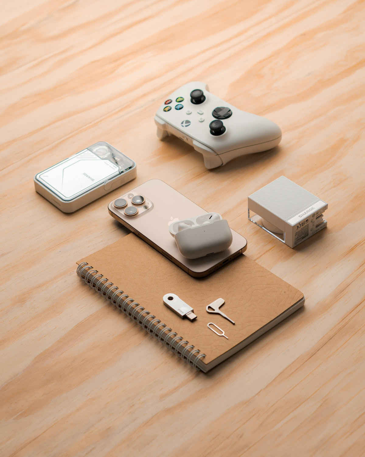 Gaming controller, smartphone, and accessories arranged on wooden surface